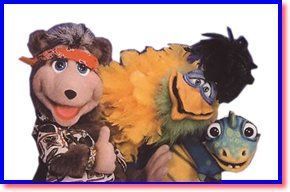 Three colorful puppet characters posing close together against a white background
