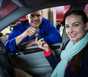 A man is holding a car key next to a woman in a car.