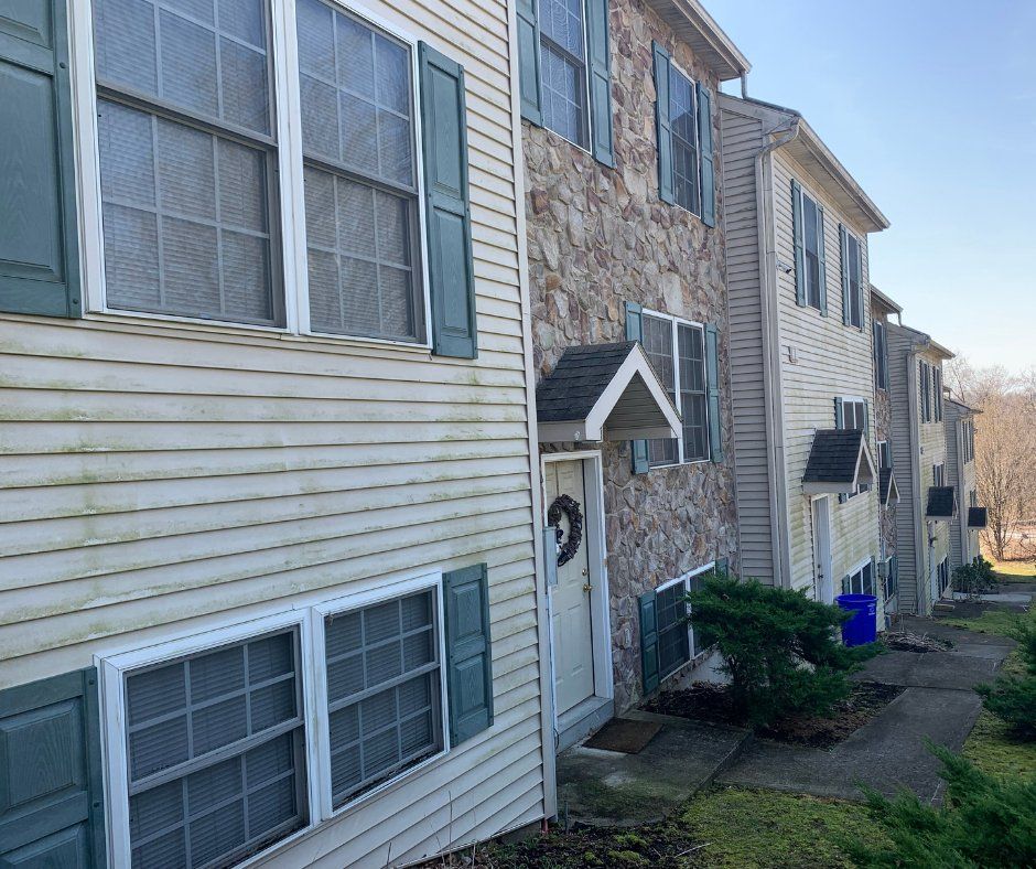 A row of houses with white siding and blue shutters
