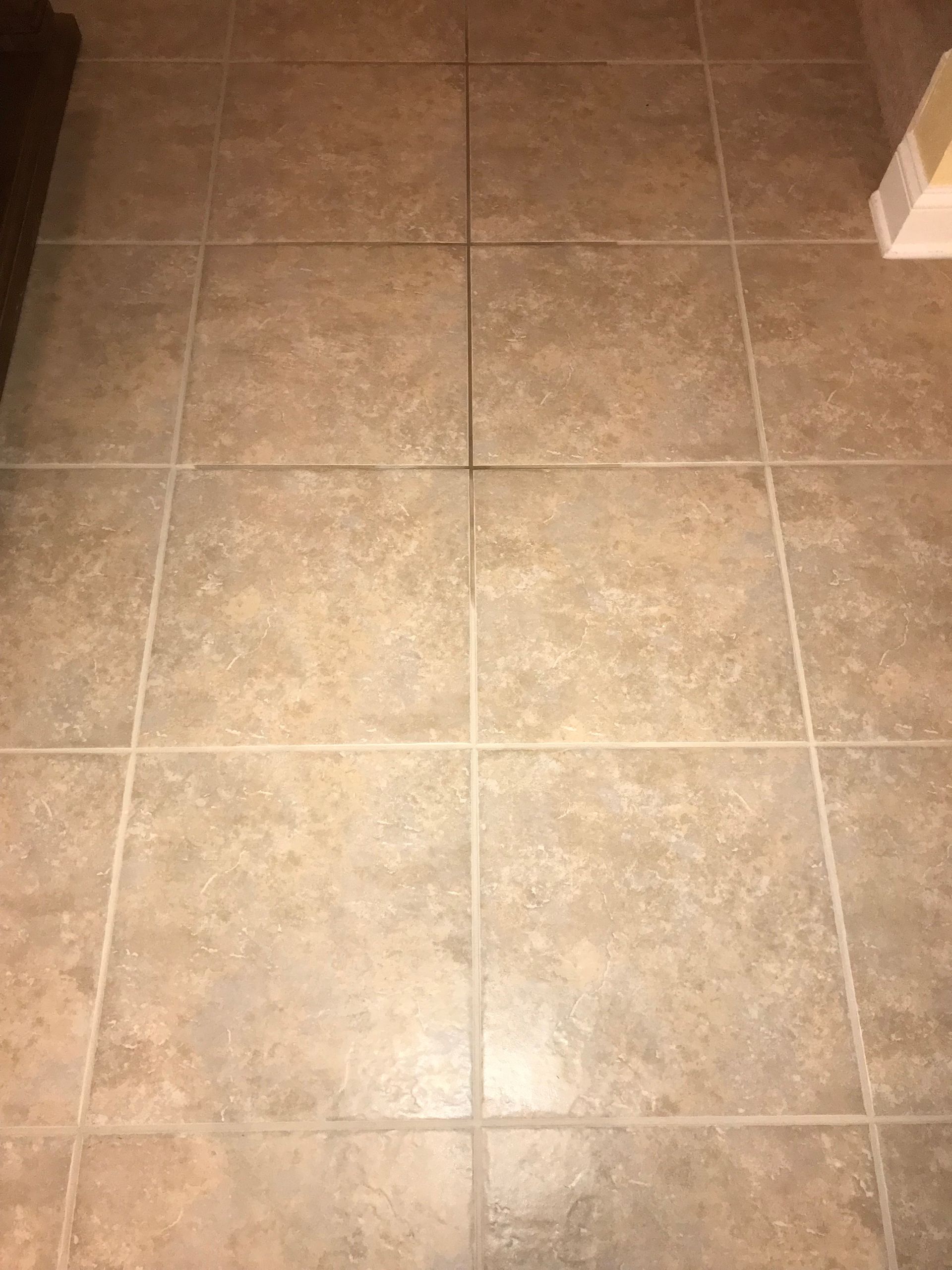 Beige ceramic tile floor with dark grout lines.