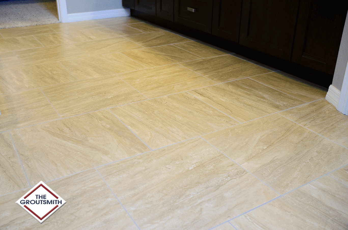 Beige tile flooring in a diagonal pattern with dark brown cabinetry in the background.