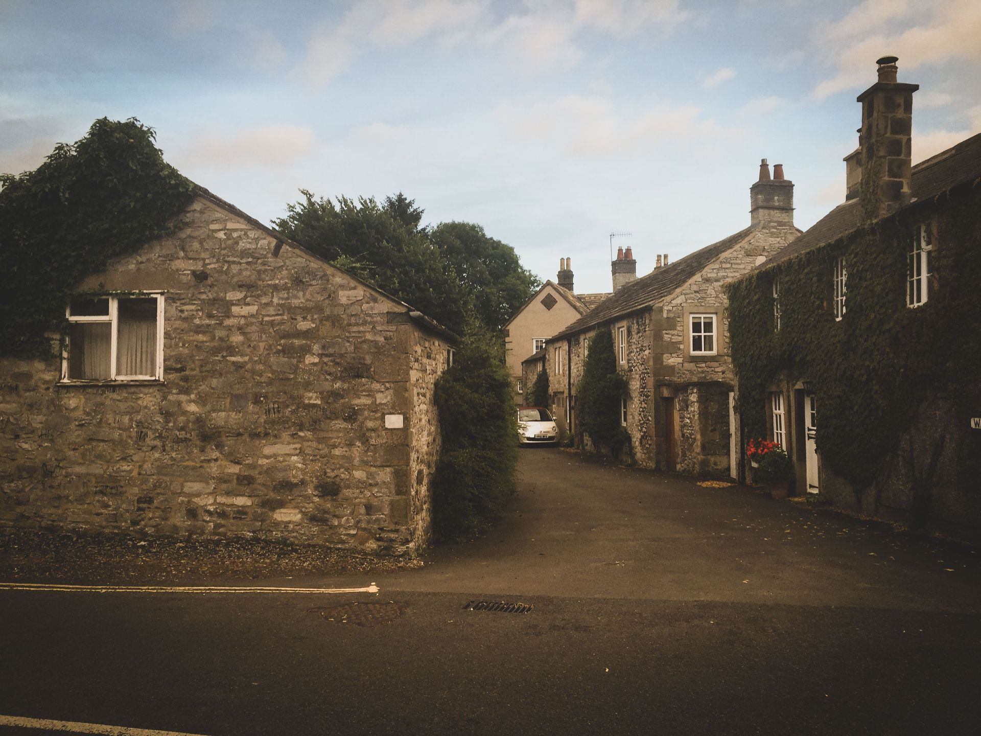 Stone village street with old cottages and chimneys under a cloudy sky