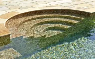 Gradini in pietra che conducono a una piscina limpida con acqua cristallina.