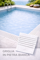 Piscina con griglia in pietra bianca, acqua turchese, posizione esterna soleggiata.
