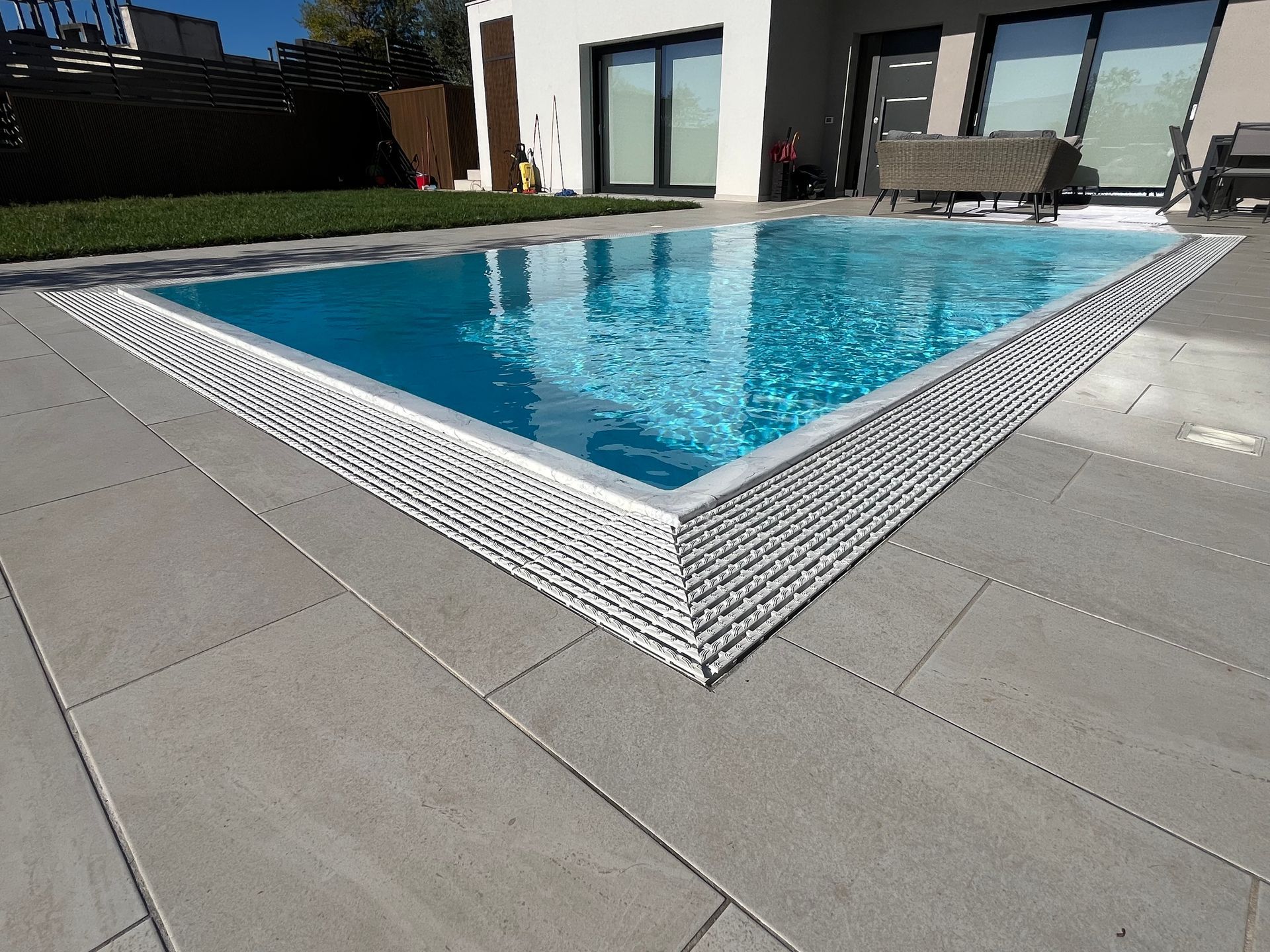 Piscina rettangolare con bordo piastrellato bianco