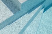 Immagine astratta di ombre blu su una superficie bianca strutturata.