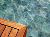 Angolo del terrazzo in legno accanto all'acqua limpida della piscina