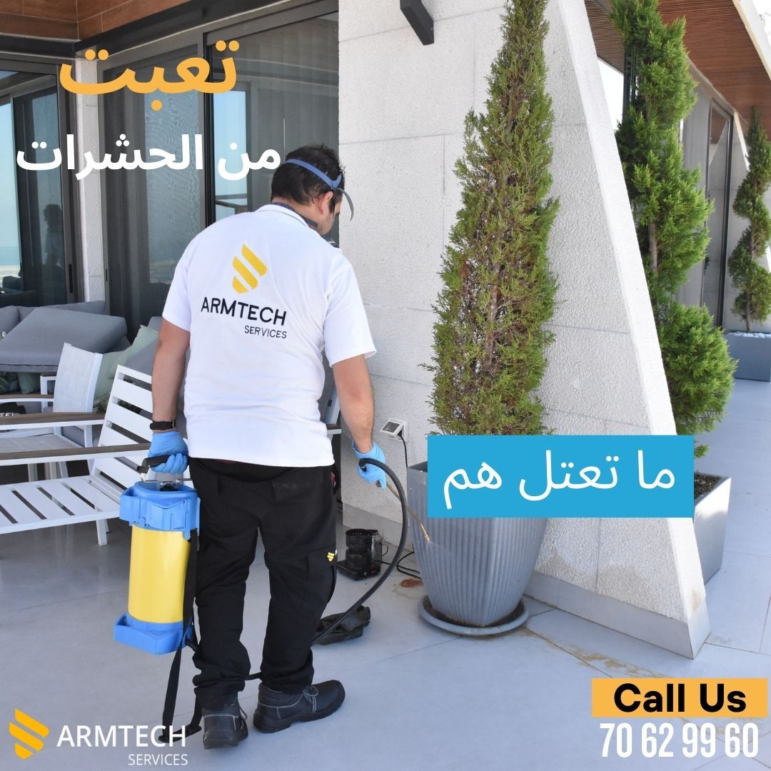 A man wearing a shirt that says armtech spraying something