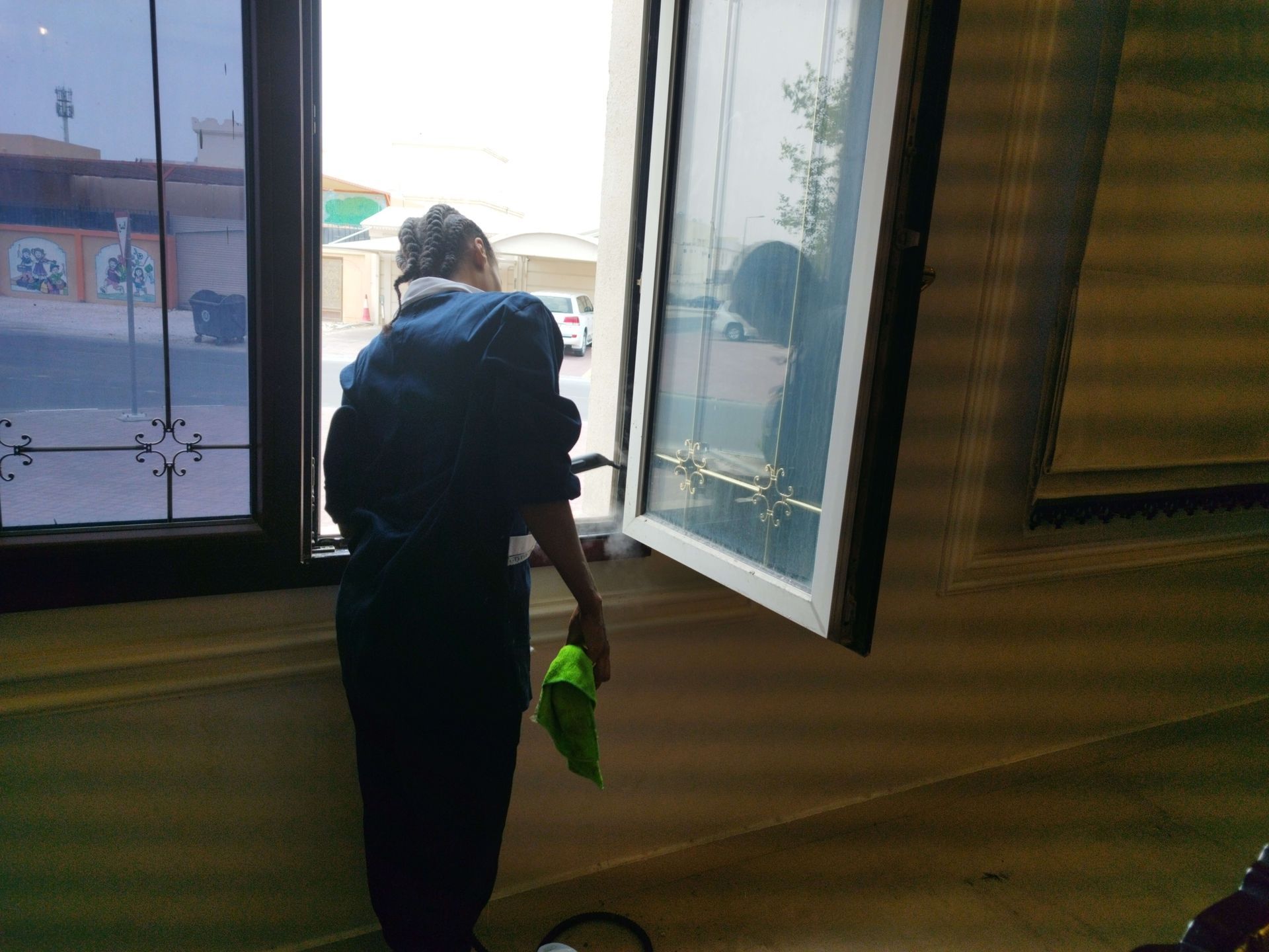 A man cleaning a window with a green cloth