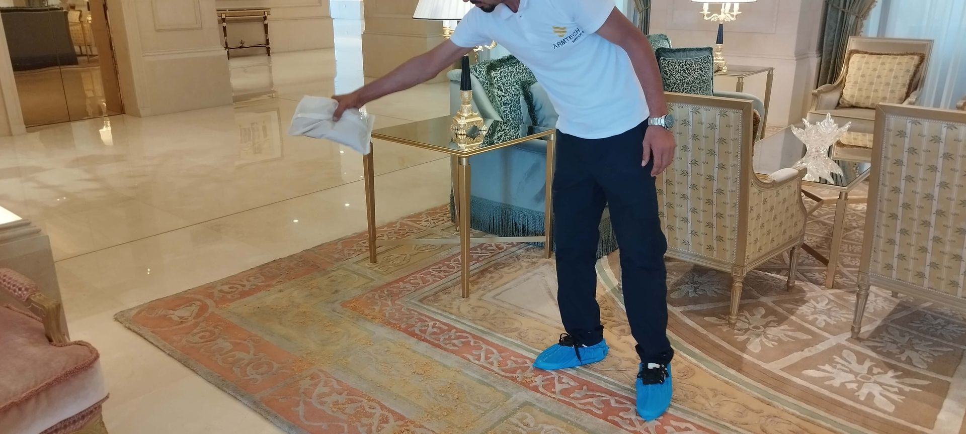 A man in a white shirt and blue shoes is standing in a living room