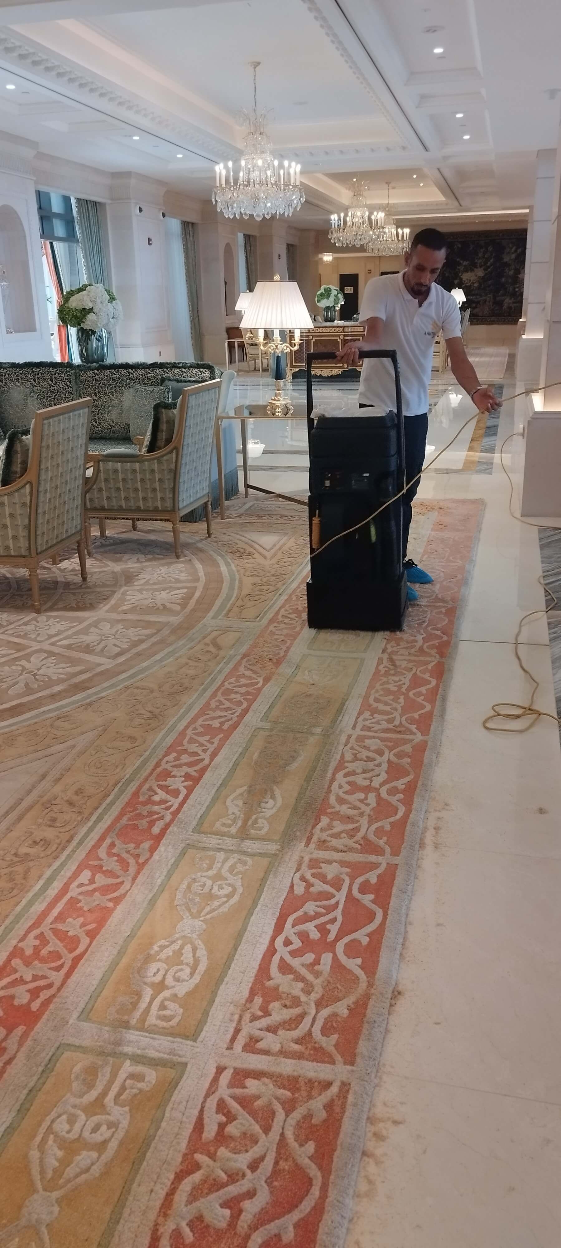 A man is standing next to a suitcase in a large room.
