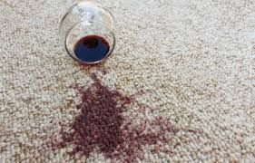 A glass of wine spilled on a carpet.