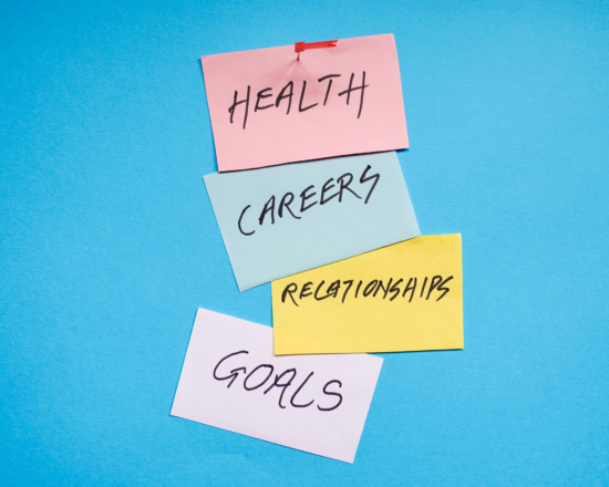 Sticky notes reading health, career, relationships, and goals on a blue background.