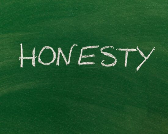 White chalk word “HONESTY” on a green chalkboard.