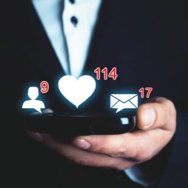 Smartphone with social media notifications: user, likes, and messages icons glowing in hand