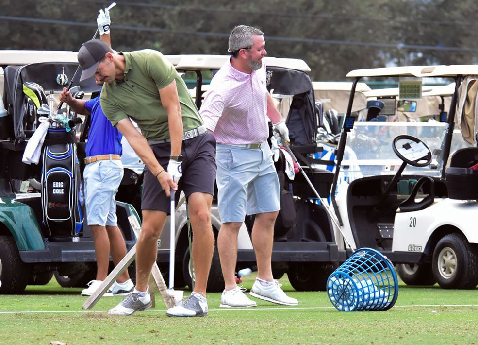 A group of men are playing golf on a golf course.