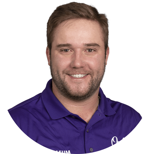 Smiling man with brown hair, wearing a purple polo shirt with a logo.