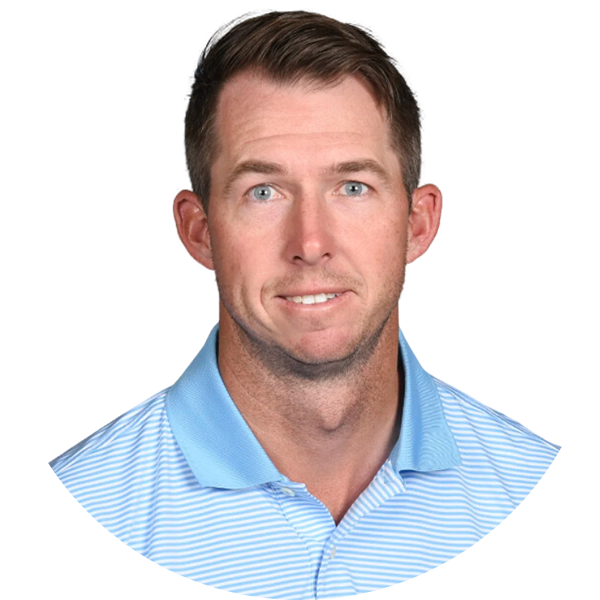 Golfer, smiling, wearing a light blue and white striped collared shirt.