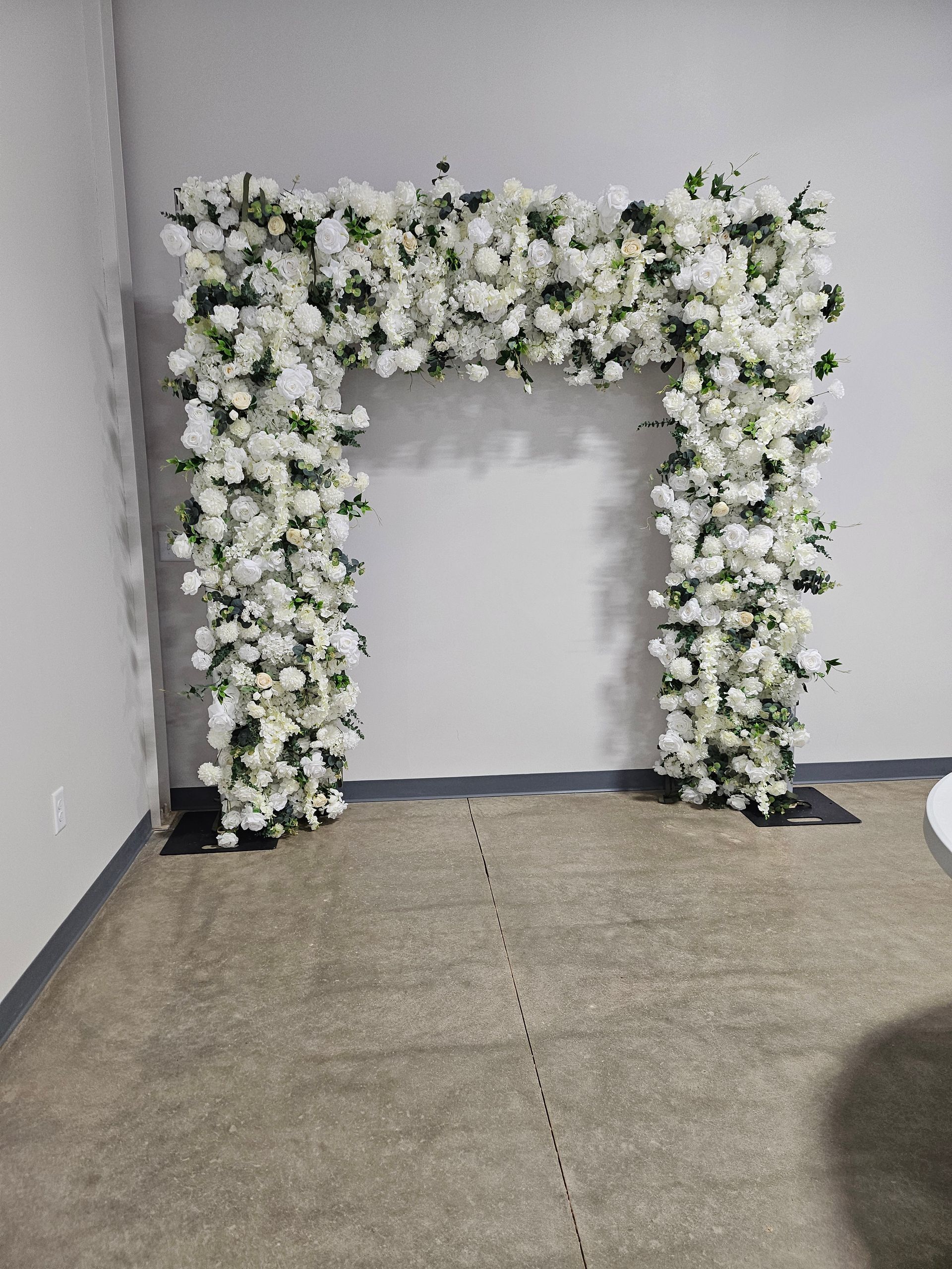 White floral archway against a gray wall on a carpeted floor