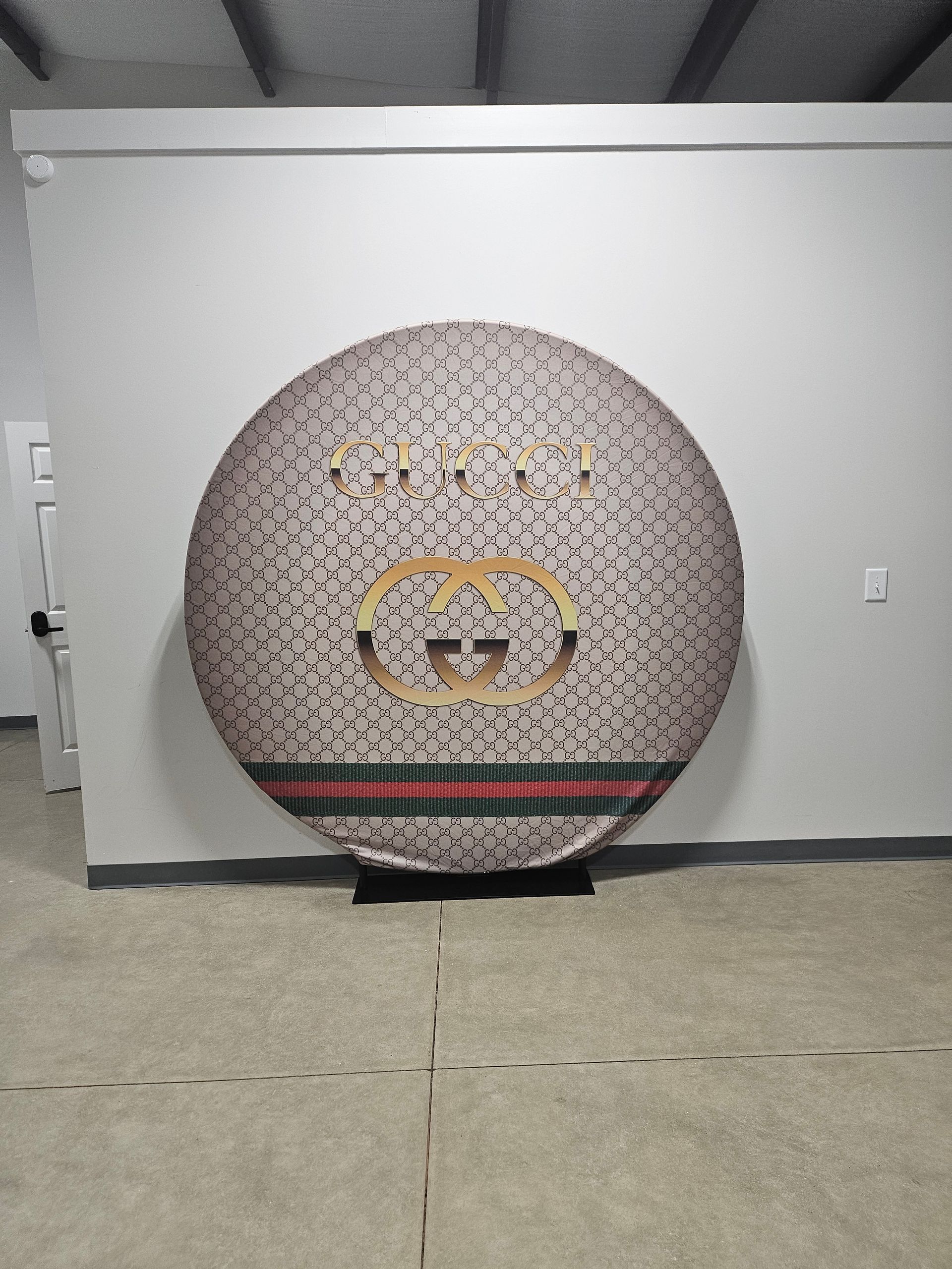 Large round patterned wall art with a smiling cartoon face on a gray indoor wall.