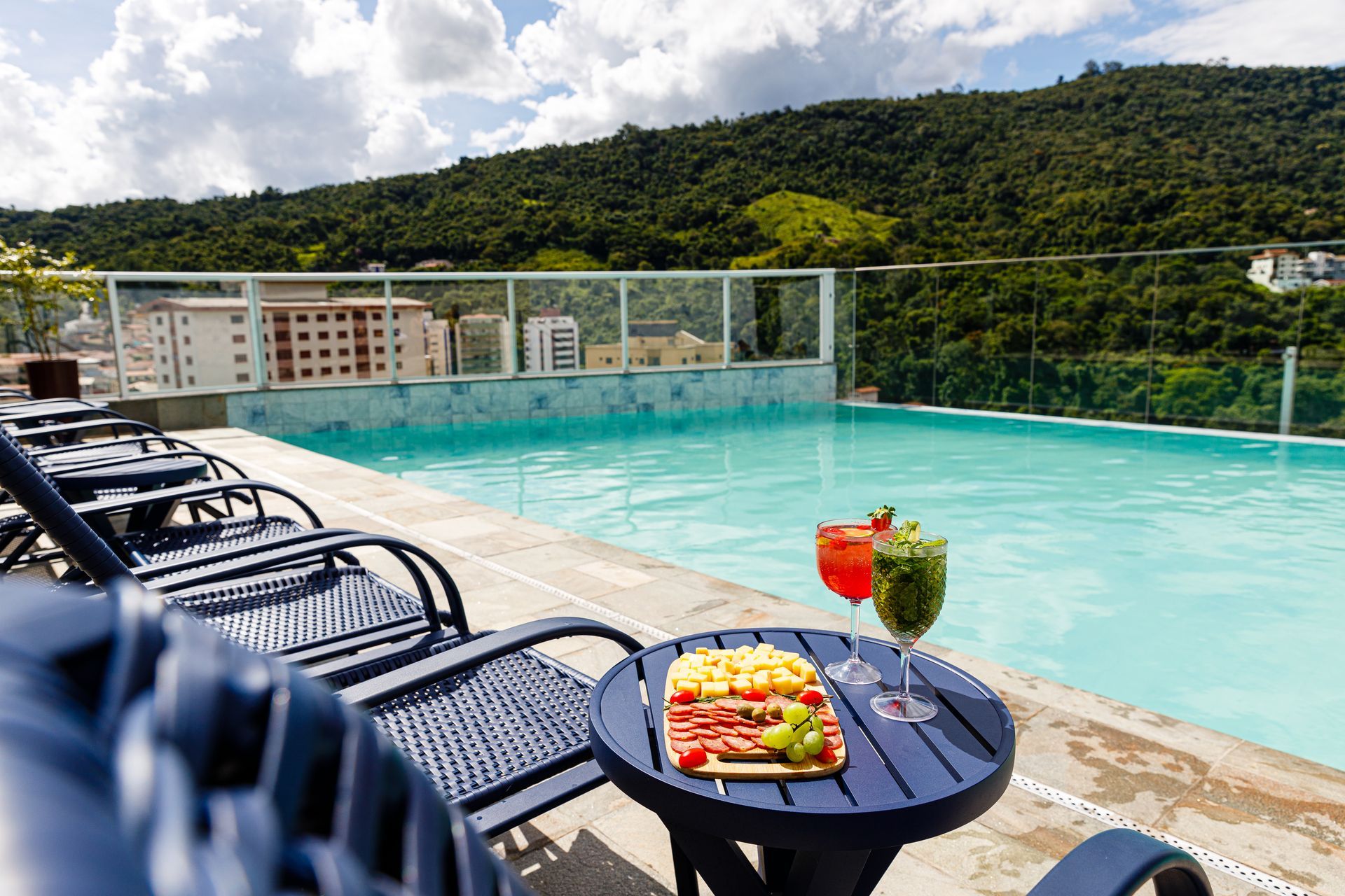 Uma piscina com uma mesa e cadeiras na frente dela.