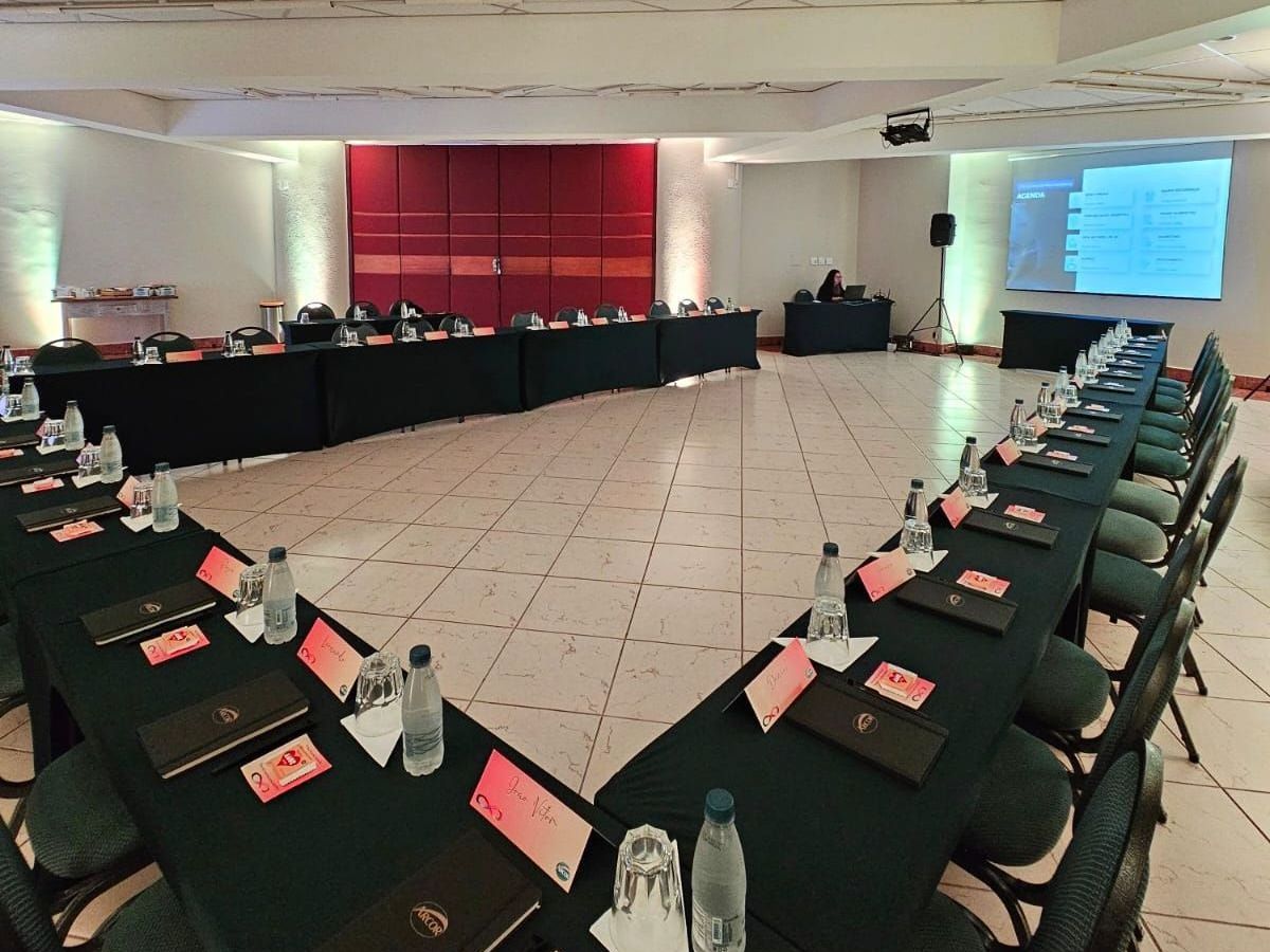 Um grupo de pessoas está em uma sala conversando entre si.