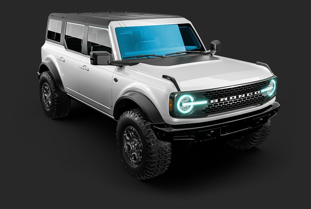 A white, four-door Ford Bronco off-road vehicle with black trim, standing against a dark grey background.