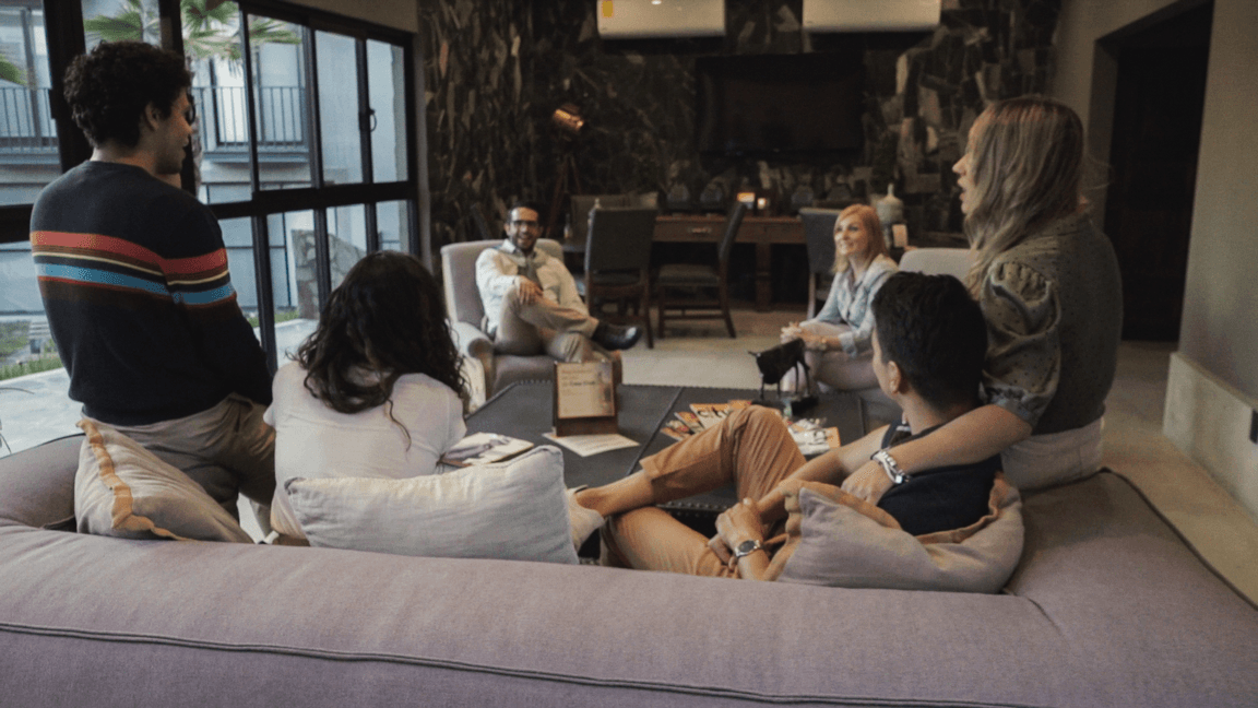 Un grupo de personas está sentada en un sofá en una sala de estar.