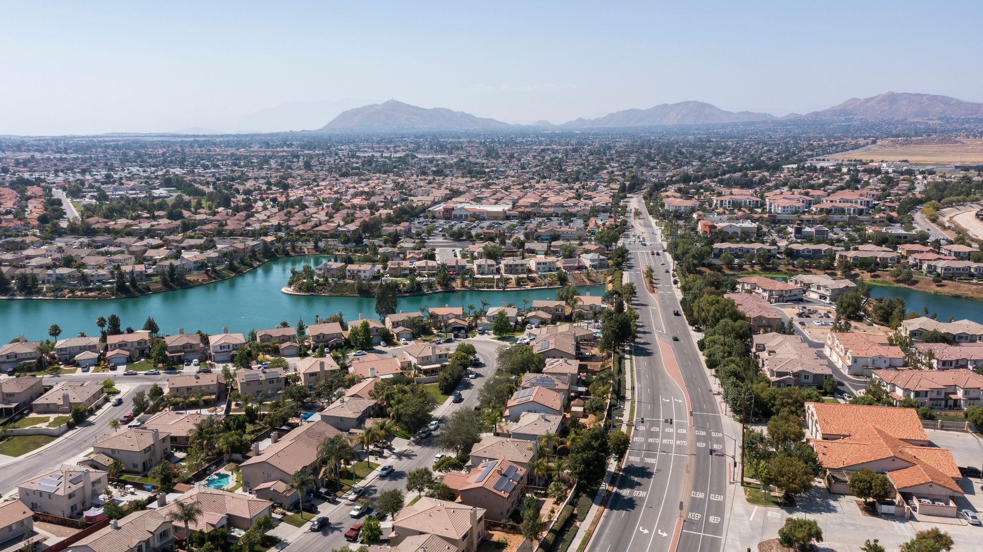 An aerial view of a residential area with a lake in the background.
