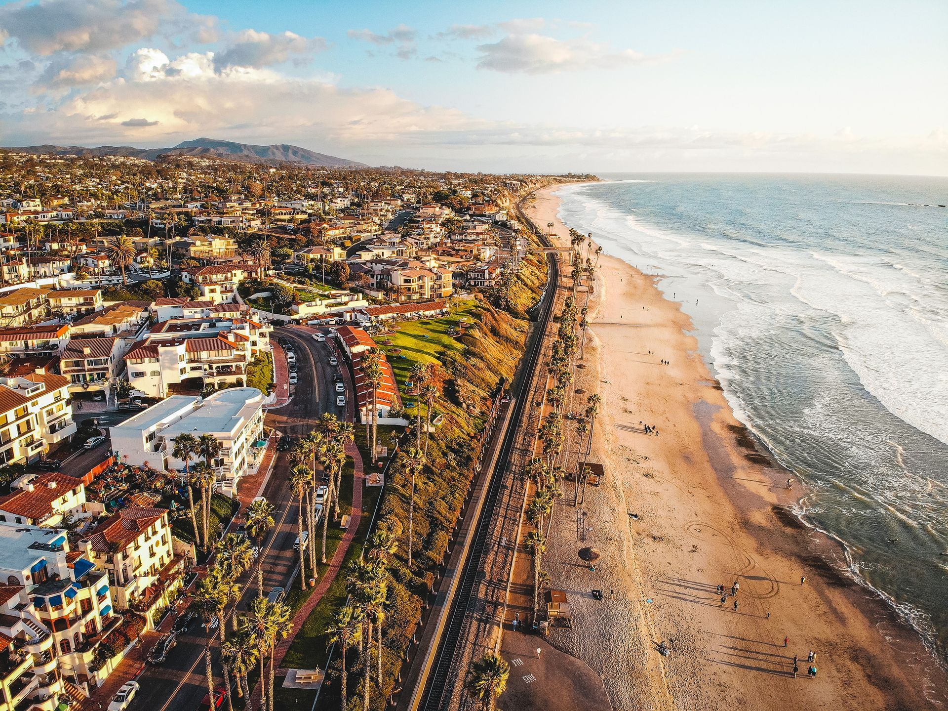 An aerial view of a beach with a city in the background.