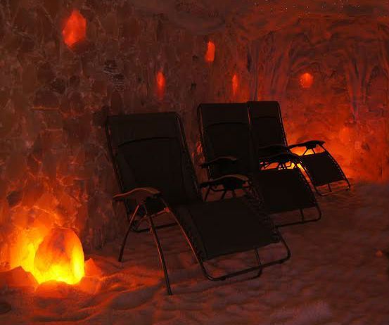 Two lounge chairs in a salt cave with orange glowing salt formations.