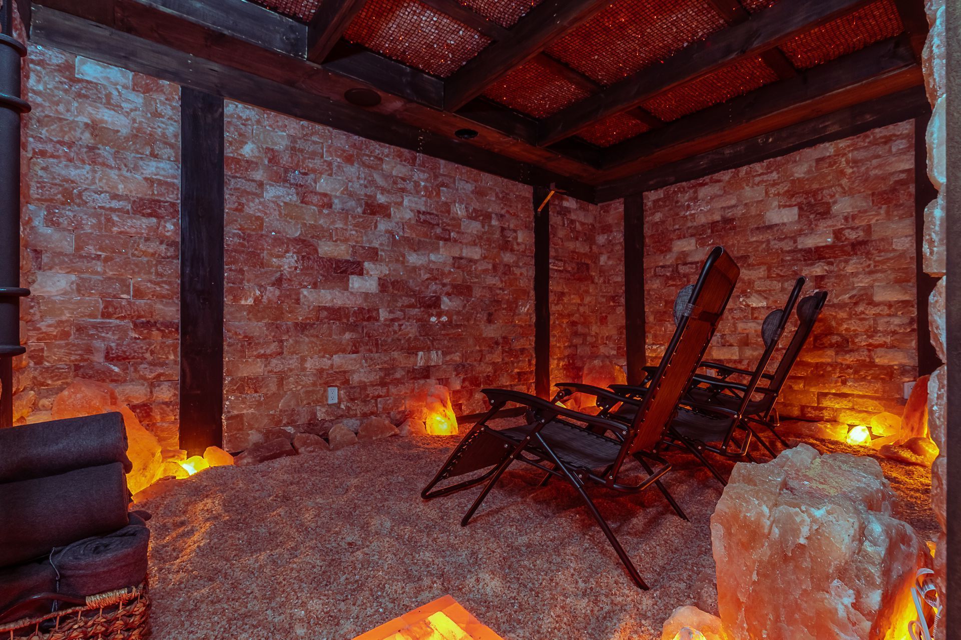 Salt room with two chairs, Himalayan salt walls, dim lighting.