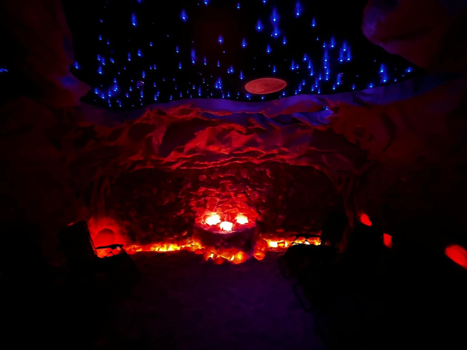 Cave interior illuminated with red and blue lights; glowing lava at the bottom, blue light 'raindrops' from above.