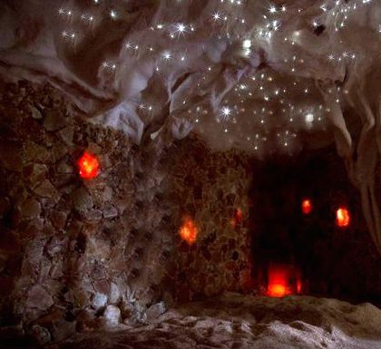 Cave interior with sparkling ceiling lights, reddish-orange glowing orbs, and rough stone walls.