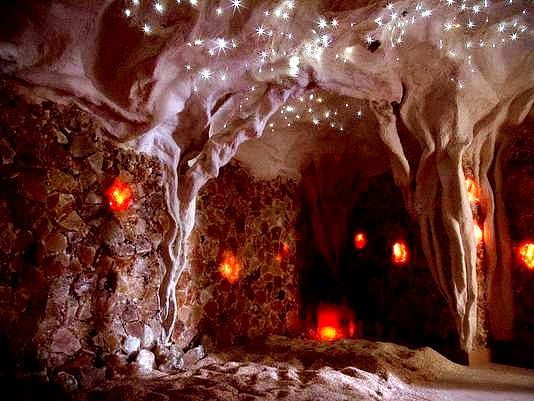 Cave interior with orange lights, stalactites, and twinkling fiber optic lights on the ceiling.