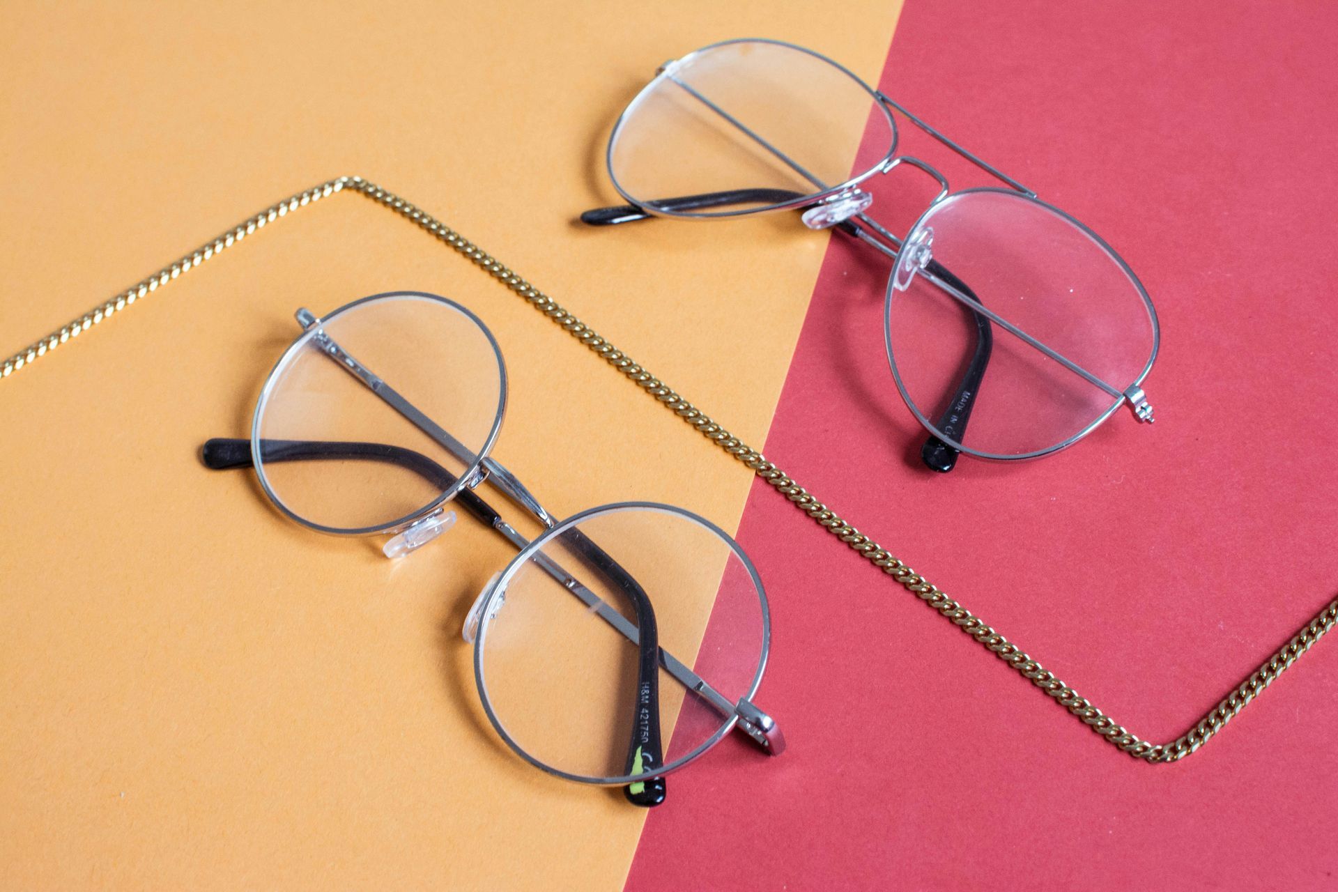 Une paire de lunettes posée sur une surface rouge et jaune.
