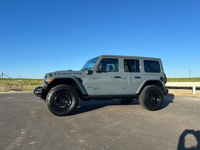 Light gray Jeep Wrangler parked outdoors, freshly coated with ceramic coating for glossy finish.
