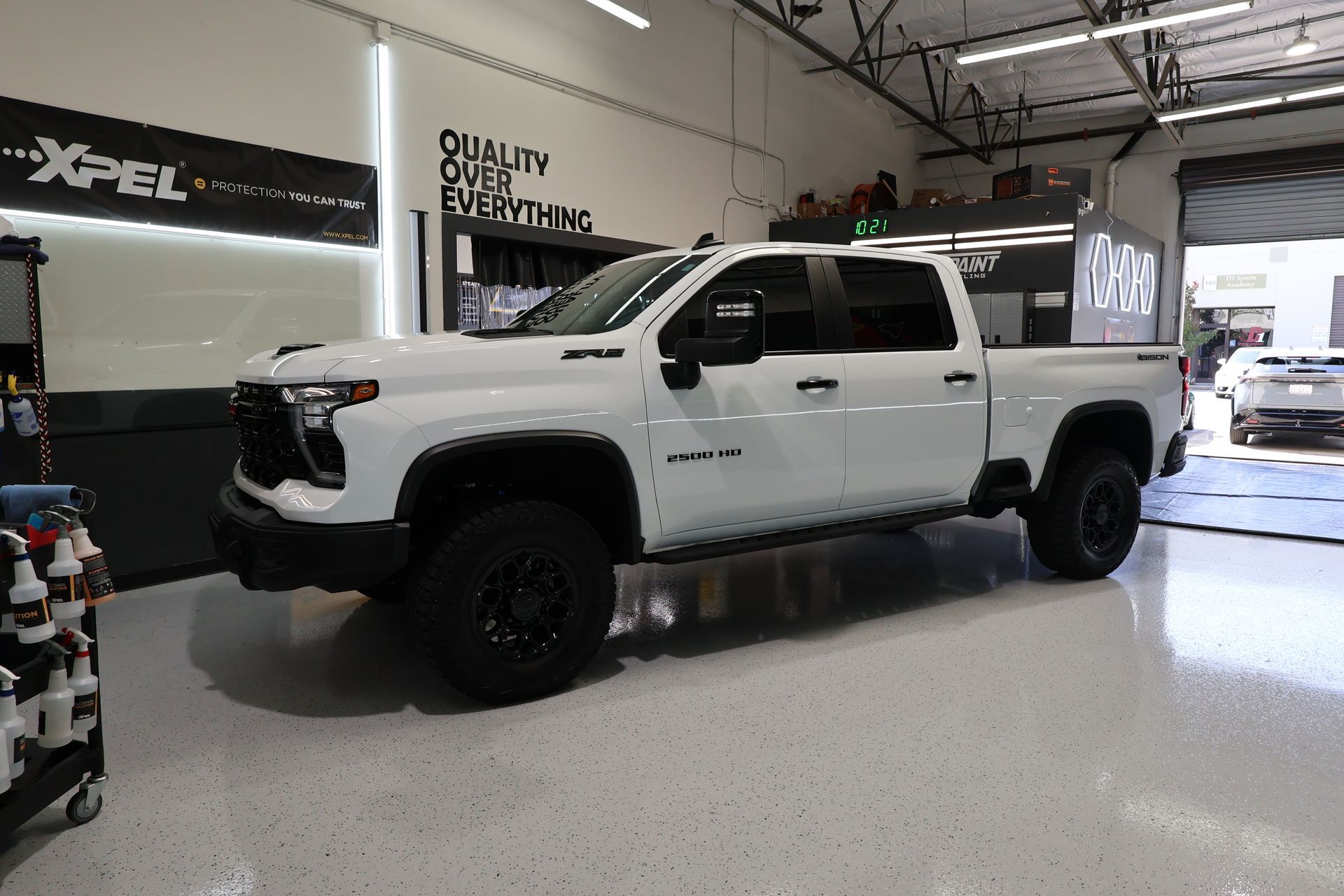 A white truck is parked in a garage.