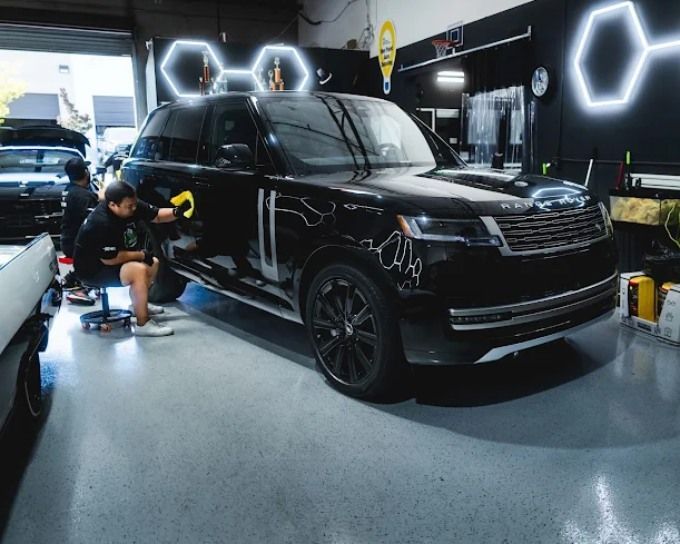 Technician applying ceramic coating to a black Range Rover at Wet Paint Auto Detailing in Roseville, CA