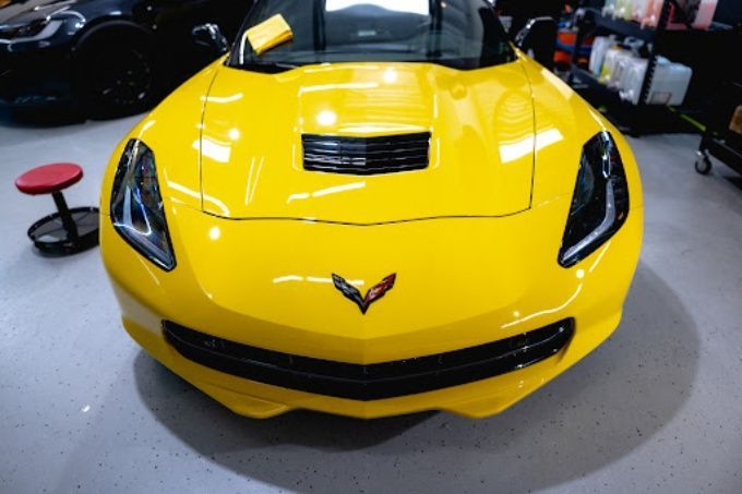 Yellow Chevrolet Corvette Z06 inside Wet Paint shop with a flawless ceramic coating on the hood