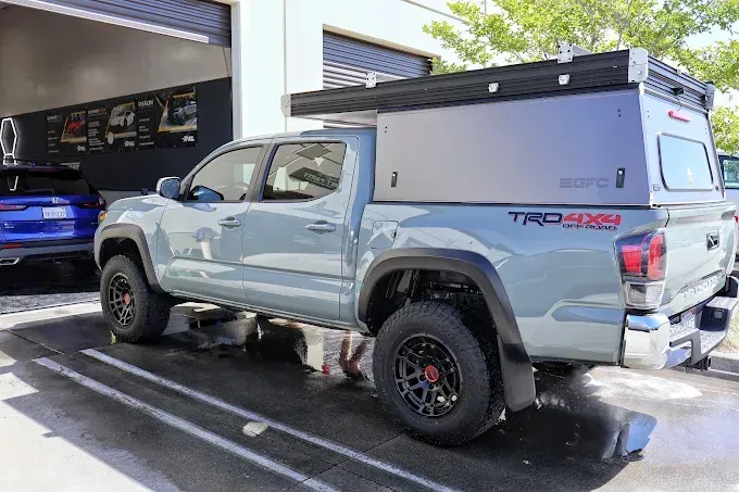 Light blue Toyota Tacoma truck with camper, freshly coated with ceramic coating for glossy finish.