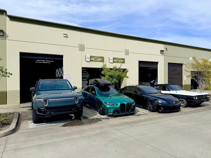 Four cars lined up outside Wet Paint auto shop after ceramic coating, including a Rivian SUV and tea