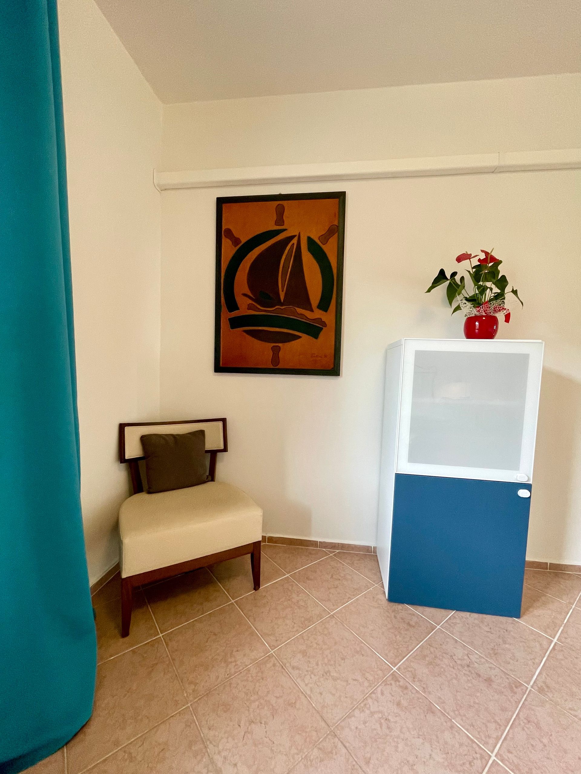 Porzione della camera doppia , poltrona, quadro in pelle e mobiletto 