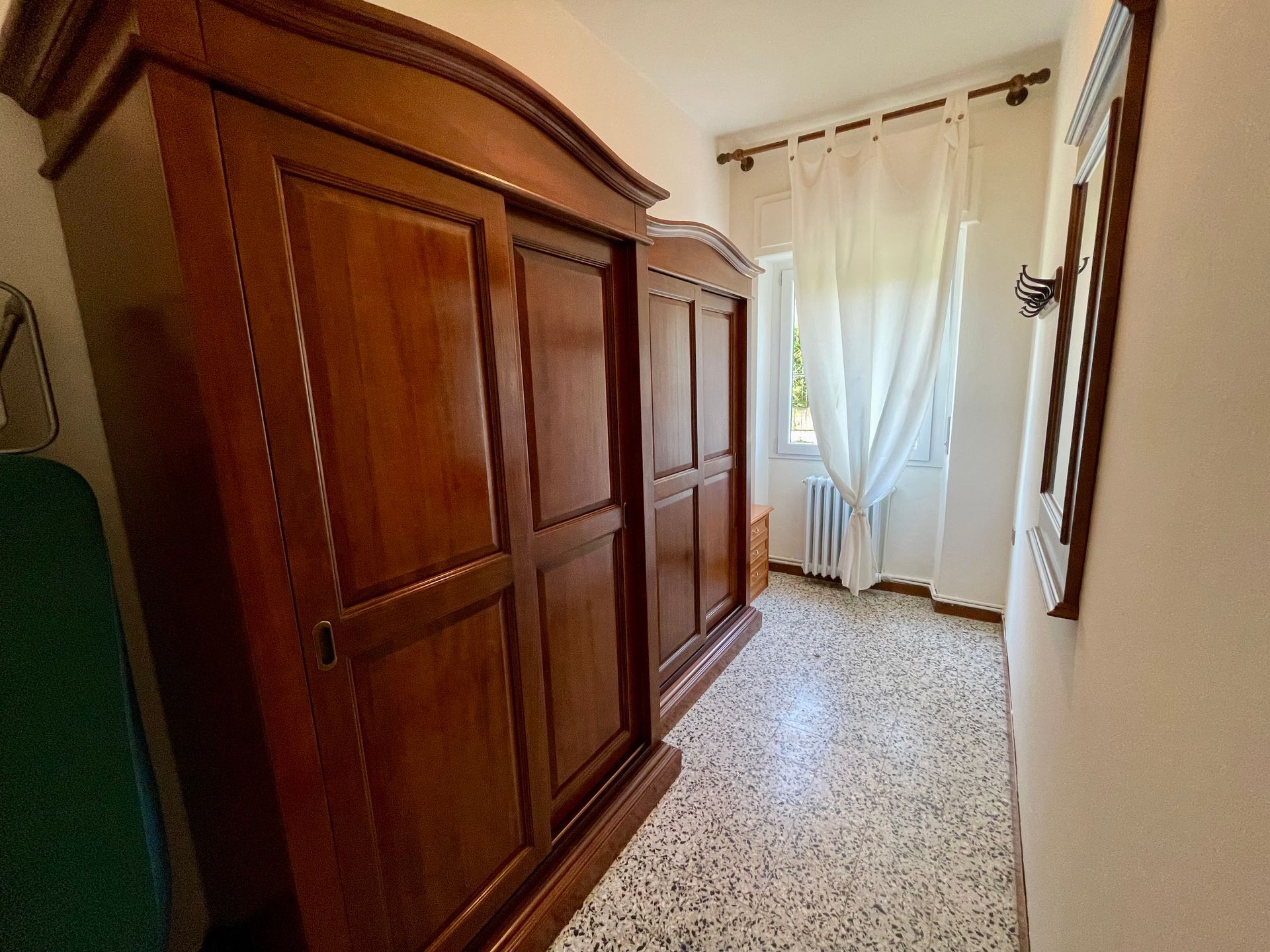 Guardaroba con due armadi in legno con porte scorrevoli, specchio, appendiabiti comodino con cassetti e attrezzatura per le pulizie