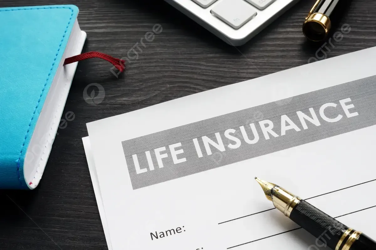 Life insurance document on a desk next to a blue notebook, pen, and keyboard.