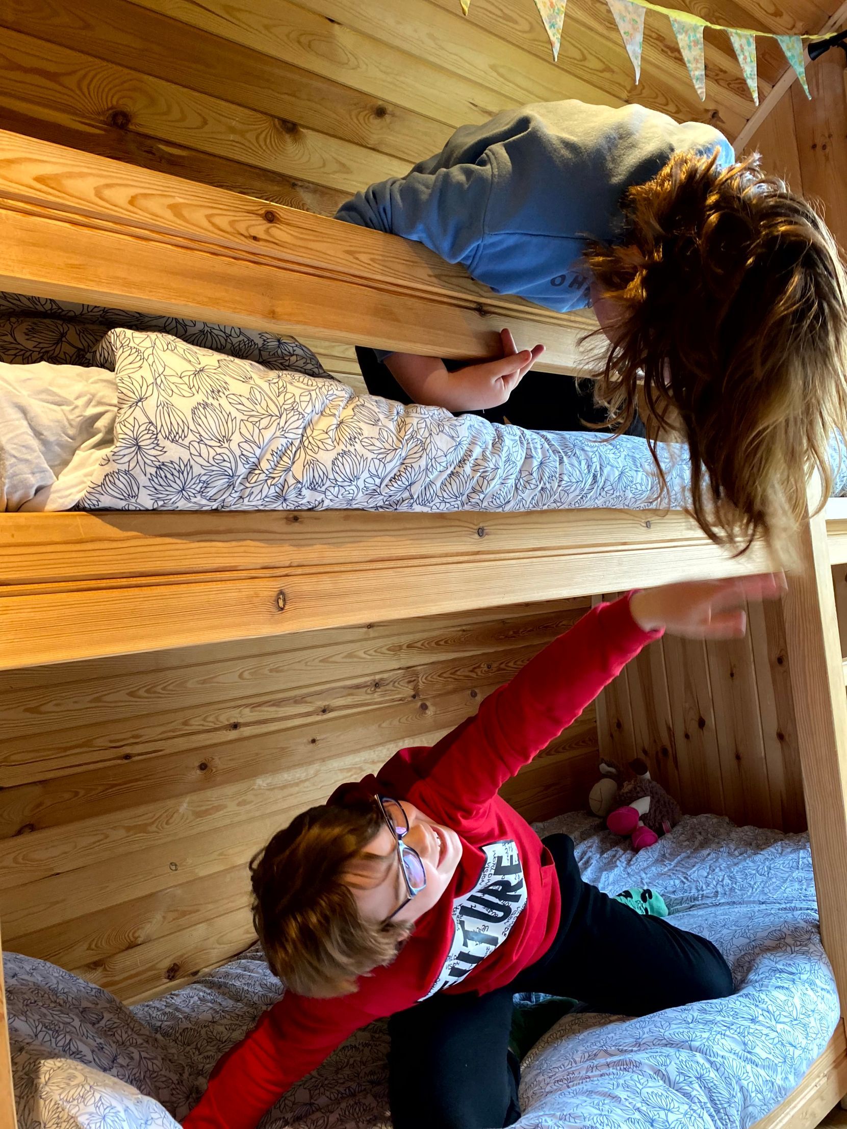 Henry leaning out of a bunk bed in a pod