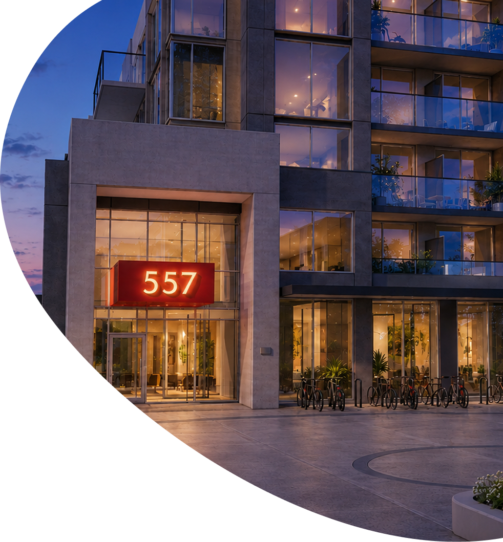 Modern apartment entrance at dusk with lit windows and red 557 sign above glass doors