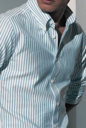 Person wearing a blue-and-white striped button-up shirt, cropped at the chest.