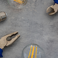 Tools and light bulbs on a gray work surface