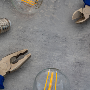 Tools and light bulbs on a gray work surface
